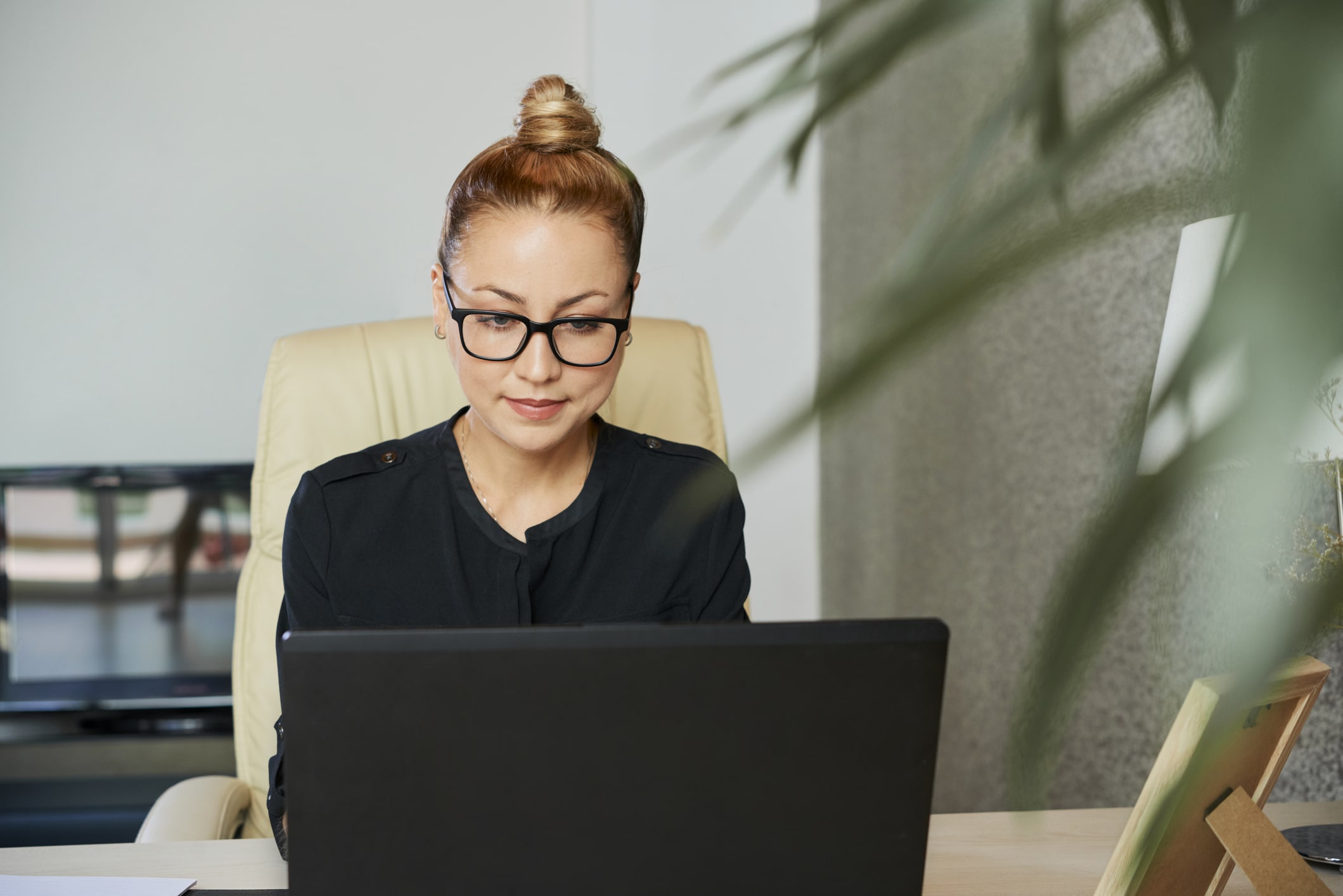 Successful businesswoman working on laptop at her office table