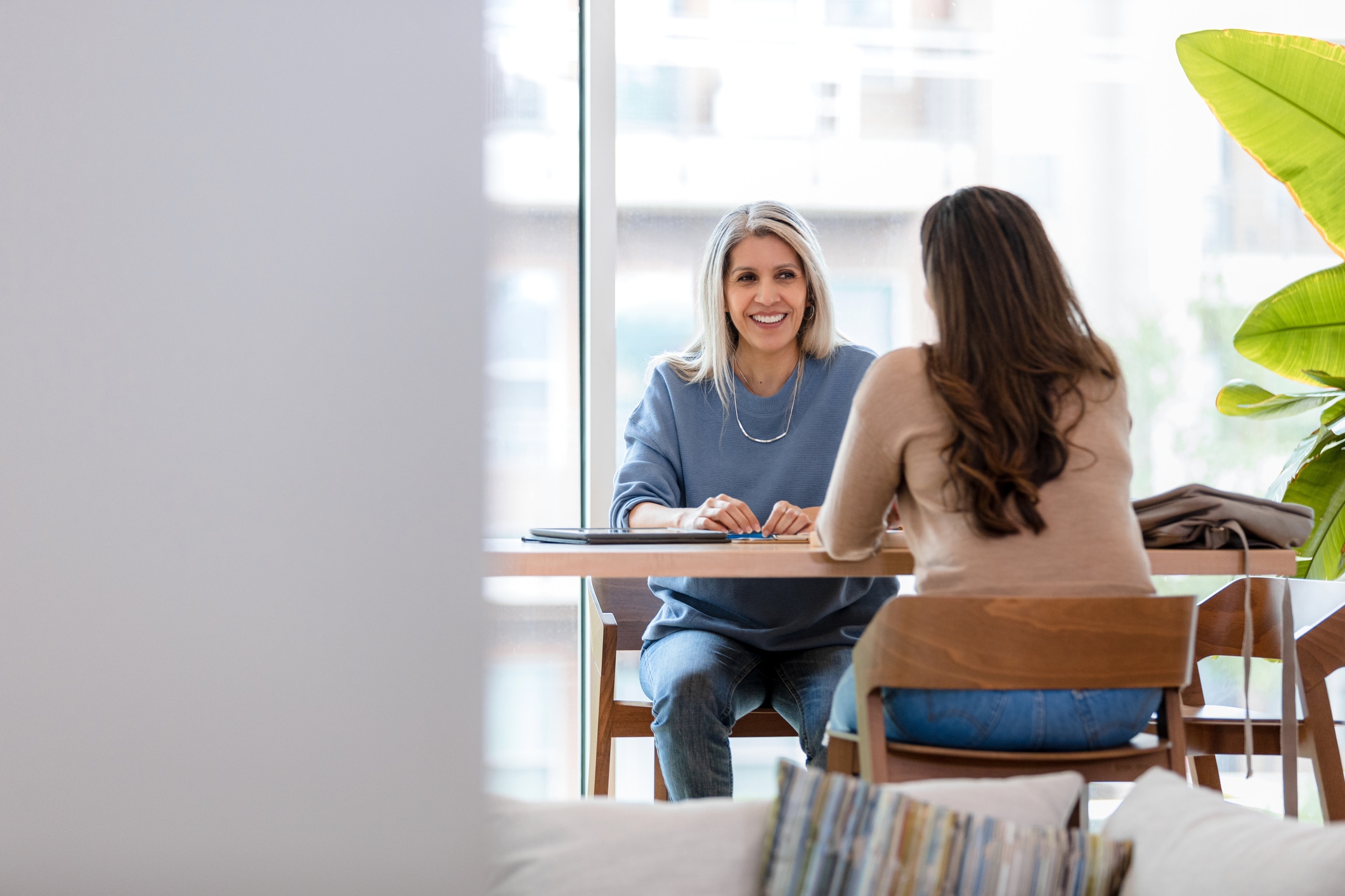 The adult woman sits with a leader from the marketing firm she would like to be employed at.